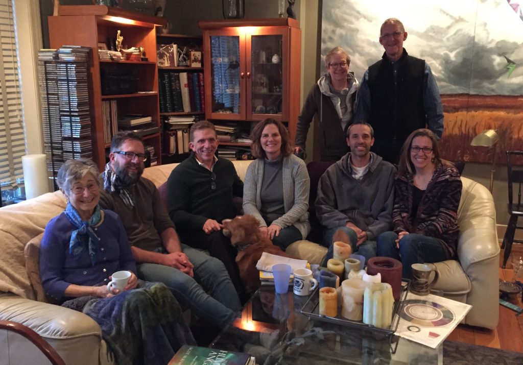 Attendees of the second Gathering sit and stand together in the home of Lesley and Gilbert Smith