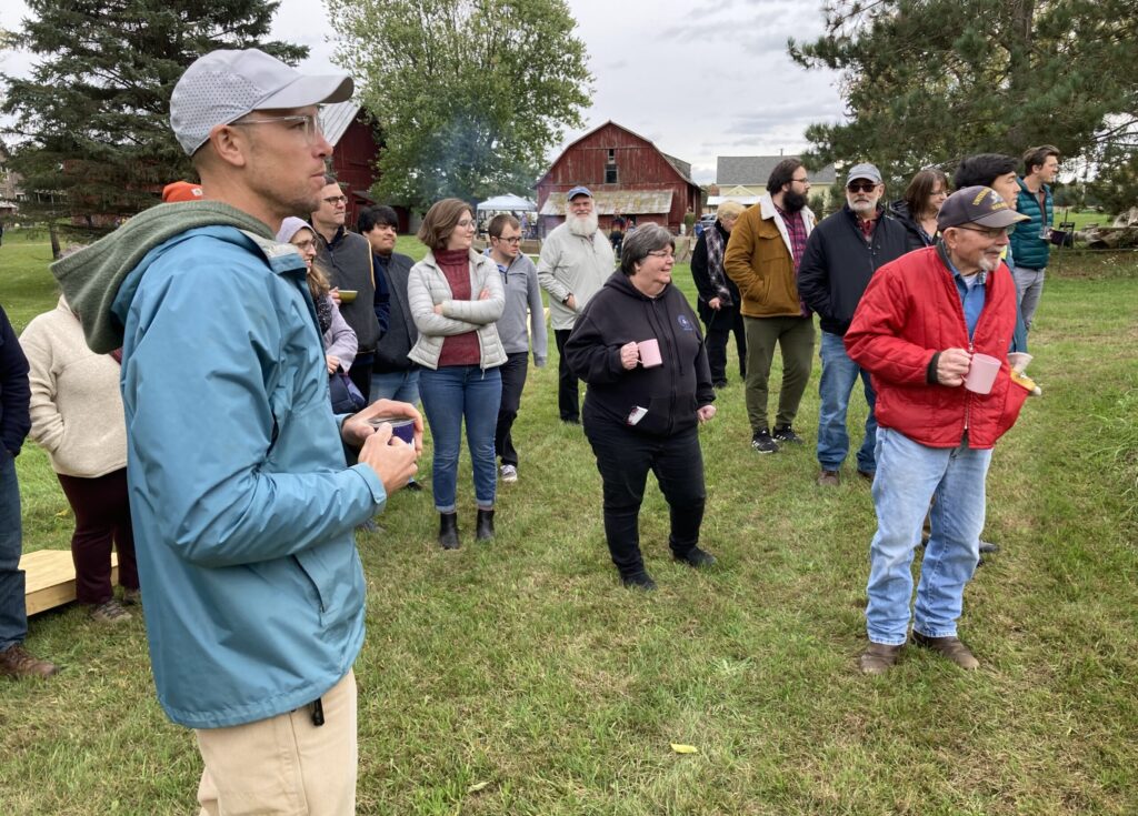 Group of diverse people looking to right with barn in background